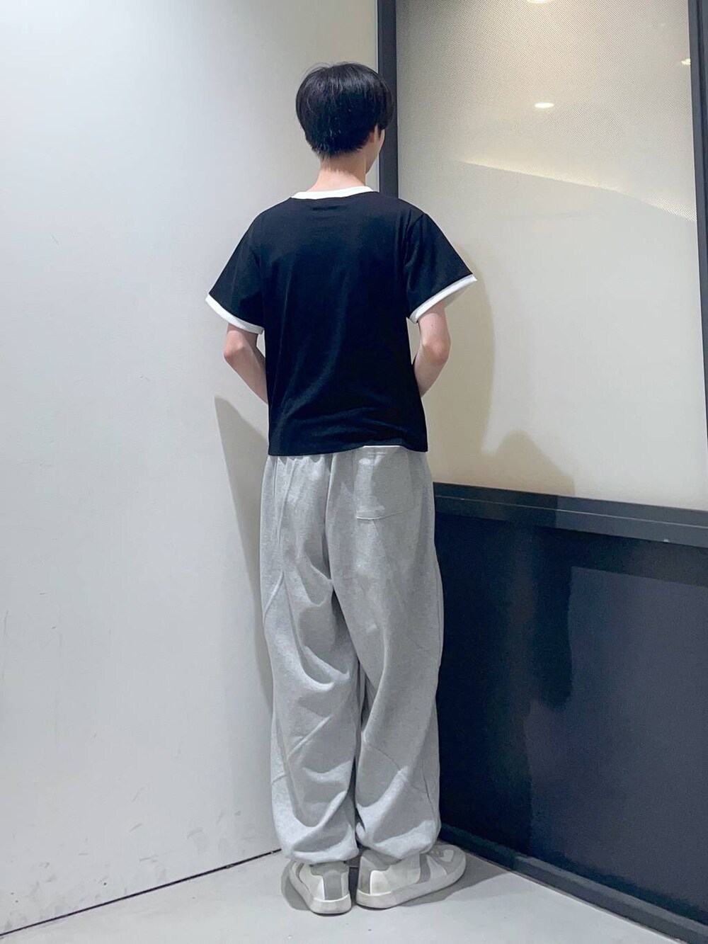 ブラック系のTシャツ/カットソー、グレー系のスウェットパンツを着用したメンズの夏コーディネートの3枚目の写真