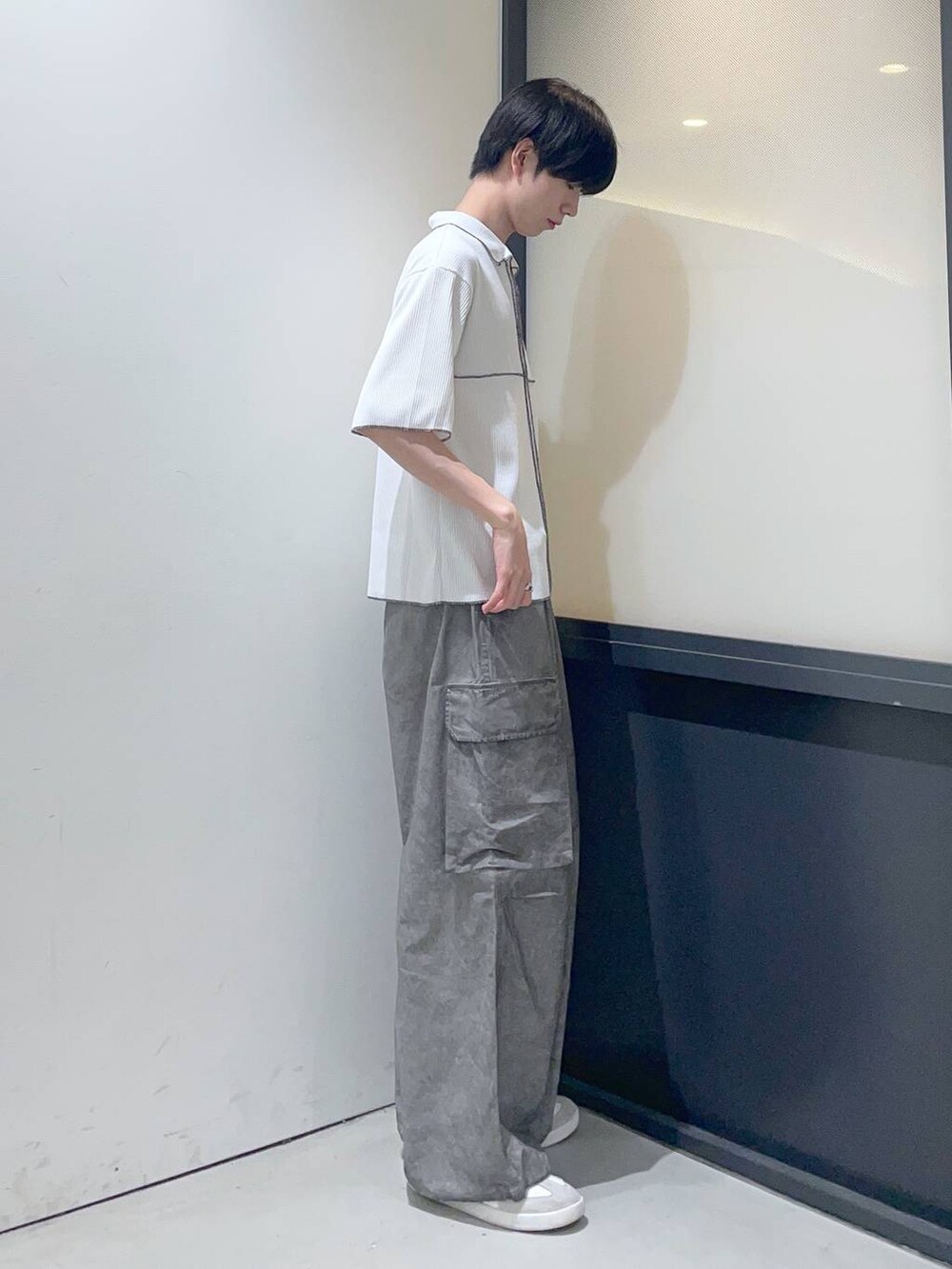 ホワイト系のポロシャツ、グレー系のその他パンツを着用したメンズの夏コーディネートの2枚目の写真