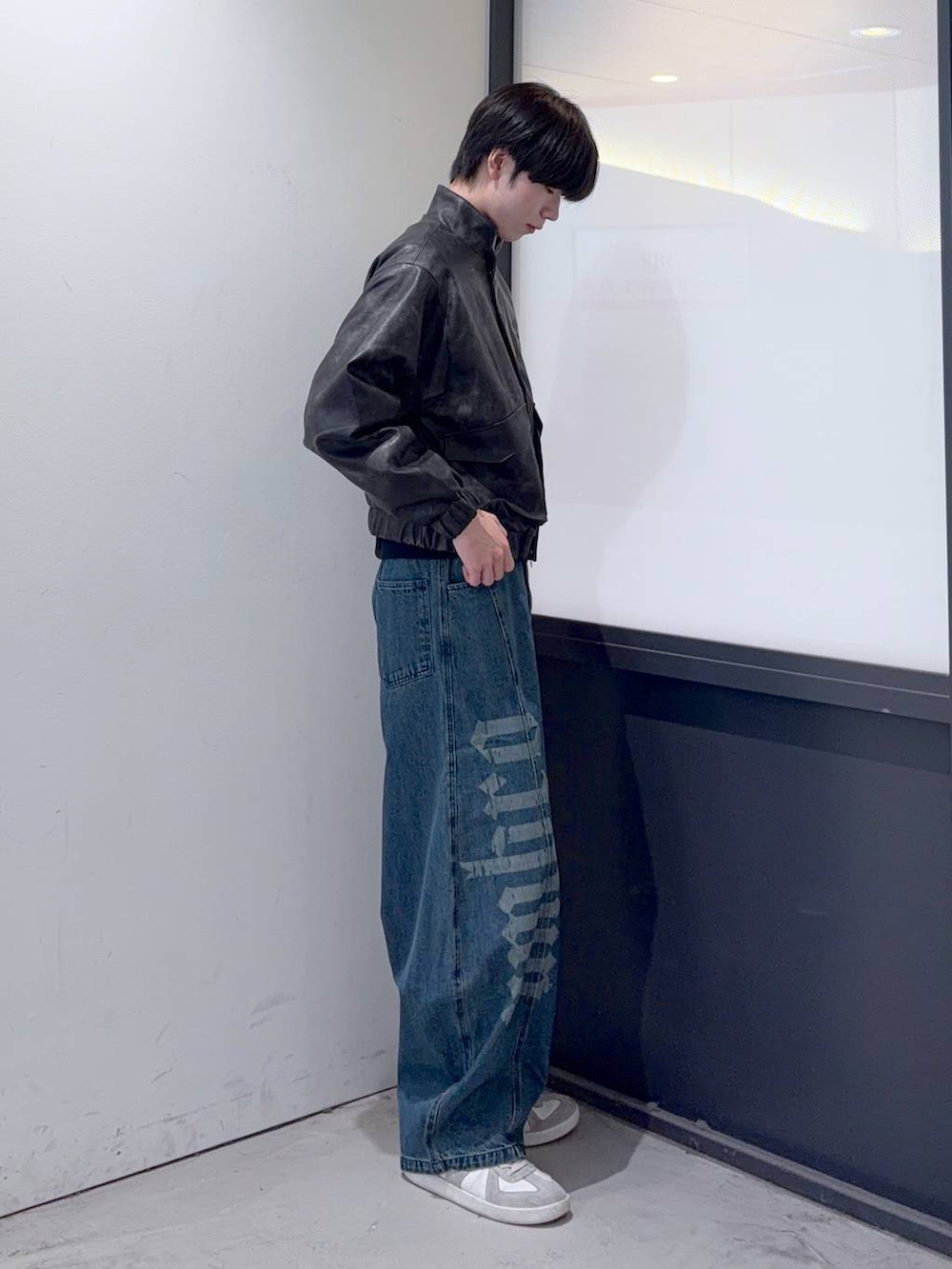 ブルー系のデニムパンツ、ブラック系のブルゾンを着用したメンズの秋コーディネートの2枚目の写真