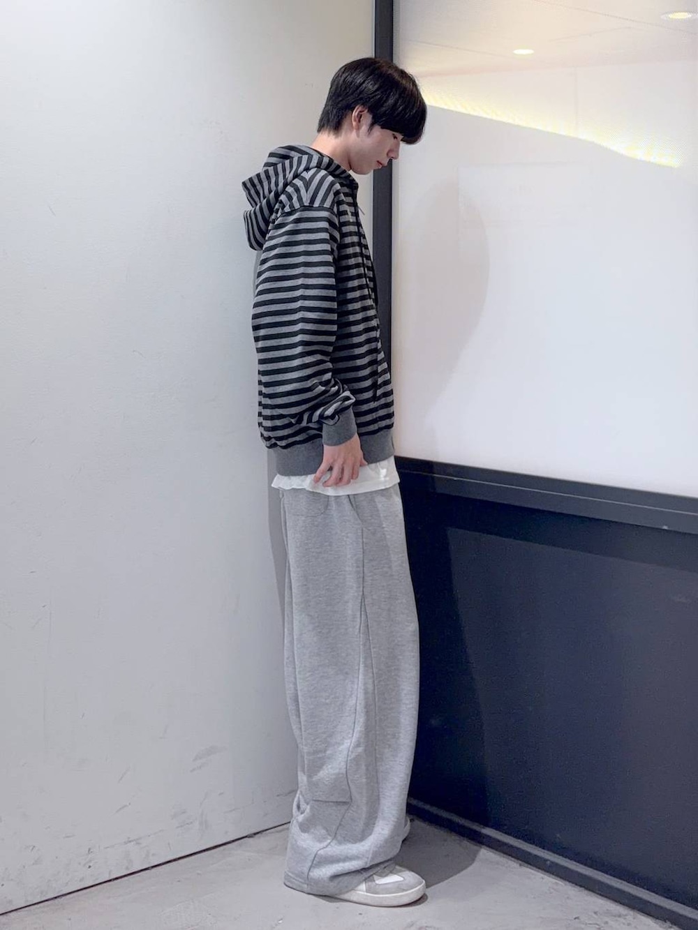 グレー系のスウェットパンツ、ブラック系のパーカーを着用したメンズの秋コーディネートの2枚目の写真