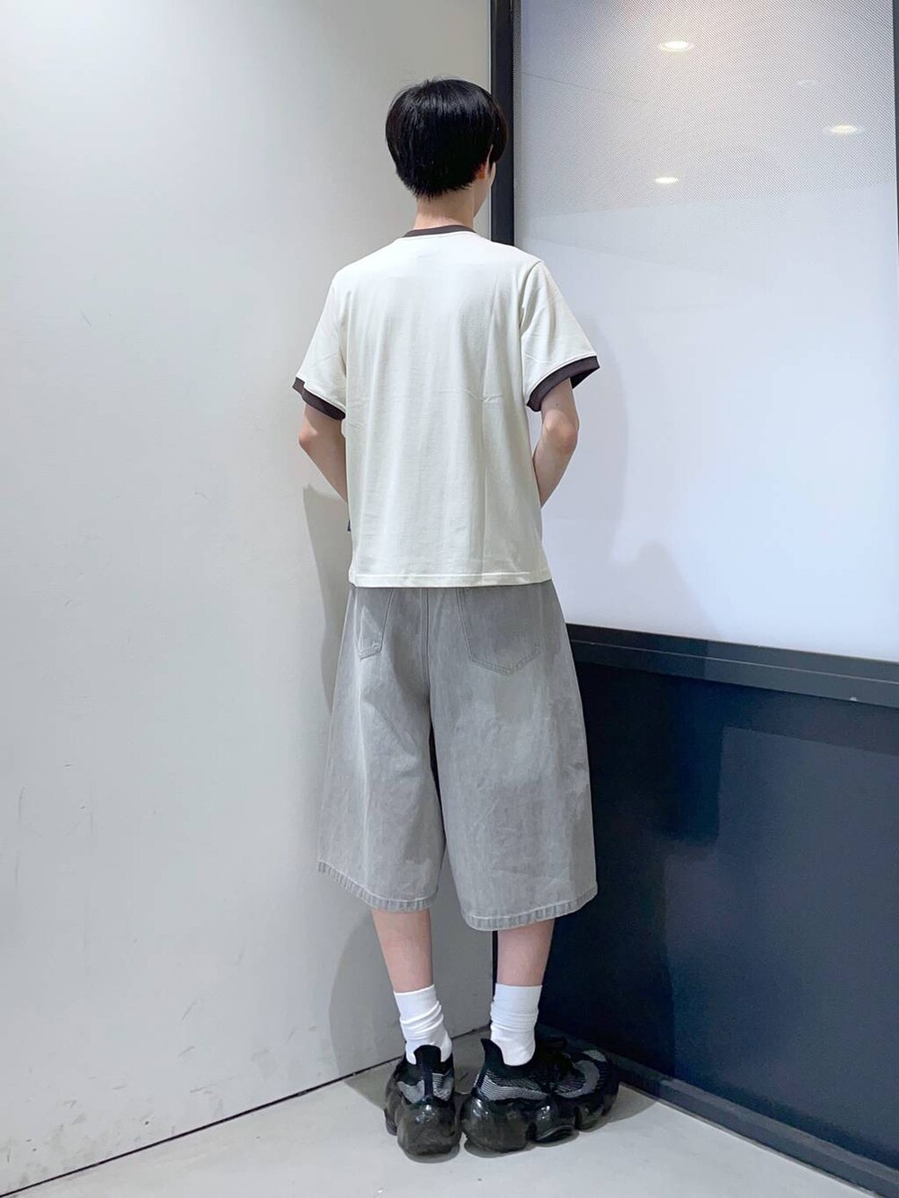 グレー系のデニムパンツ、ベージュ系のTシャツ/カットソーを着用したメンズの夏コーディネートの3枚目の写真