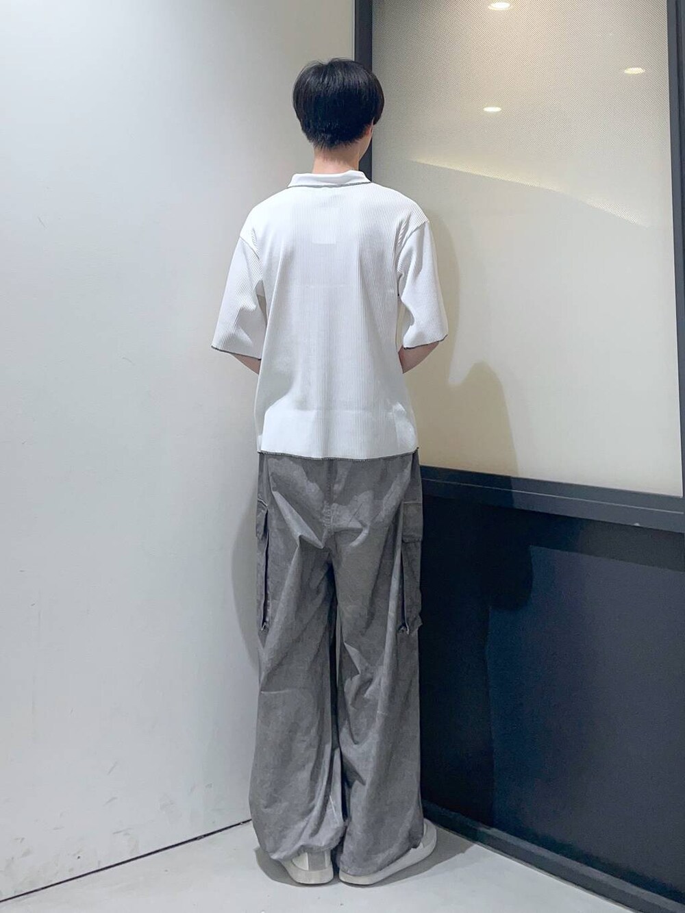 ホワイト系のポロシャツ、グレー系のその他パンツを着用したメンズの夏コーディネートの3枚目の写真