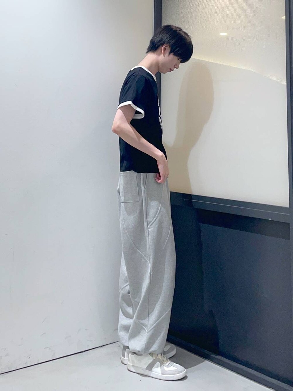 ブラック系のTシャツ/カットソー、グレー系のスウェットパンツを着用したメンズの夏コーディネートの2枚目の写真