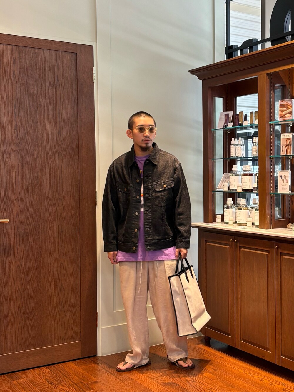パープル系のTシャツ/カットソー、ベージュ系のトートバッグ、ブラック系のデニムジャケットを着用したメンズの夏コーディネートの2枚目の写真