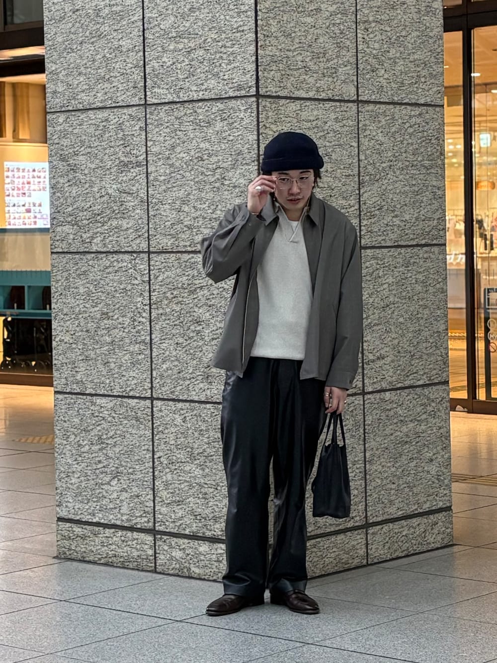 ホワイト系のポロシャツ、グレー系のブルゾン、ブラック系のショルダーバッグを着用したメンズの春コーディネートの3枚目の写真