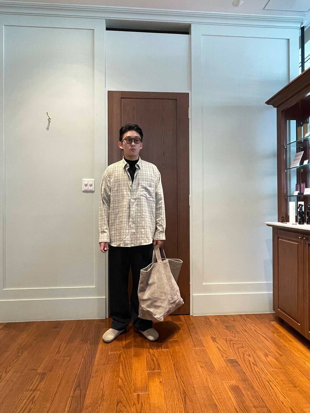 ブラック系のスラックス、ベージュ系のシャツ/ブラウス、ベージュ系のサンダルを着用したメンズの秋コーディネートの2枚目の写真