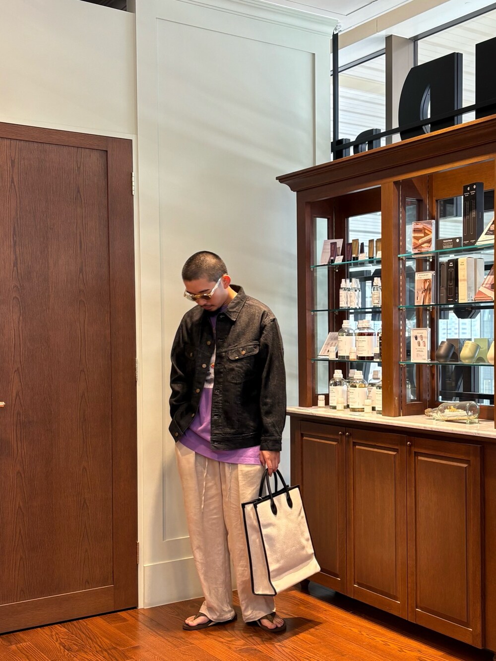 パープル系のTシャツ/カットソー、ベージュ系のトートバッグ、ブラック系のデニムジャケットを着用したメンズの夏コーディネートの4枚目の写真