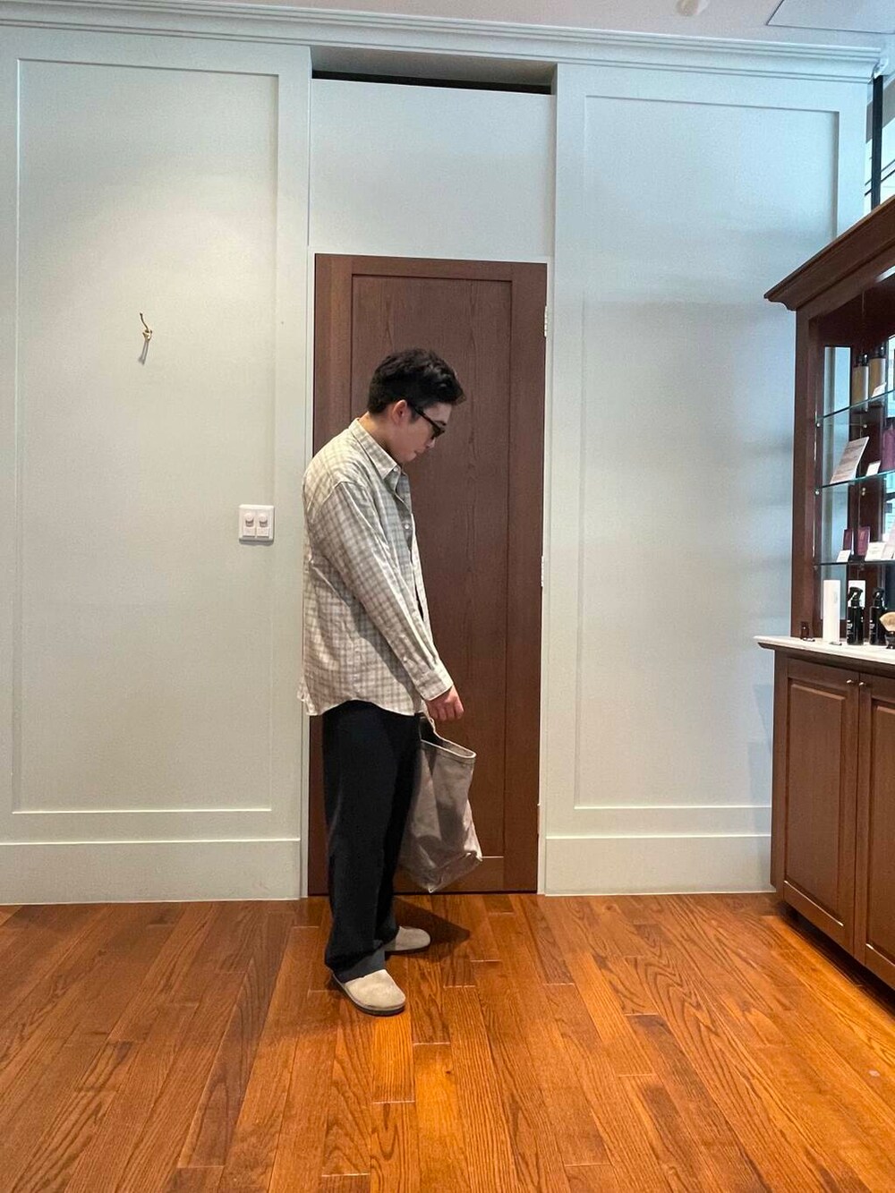 ブラック系のスラックス、ベージュ系のシャツ/ブラウス、ベージュ系のサンダルを着用したメンズの秋コーディネートの3枚目の写真