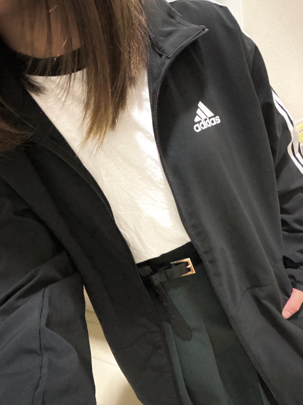 ブラック系のジャージ、グレー系のスカート、ホワイト系のTシャツ/カットソーを着用したレディースの秋コーディネートの2枚目の写真