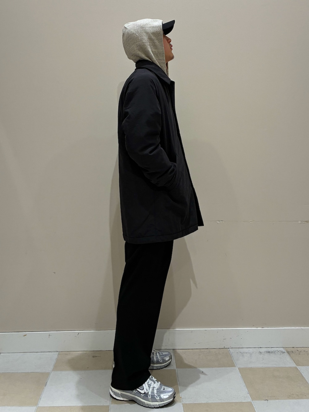 ブラック系のその他パンツ、ブラック系のステンカラーコート、グレー系のパーカーを着用したメンズの冬コーディネートの2枚目の写真