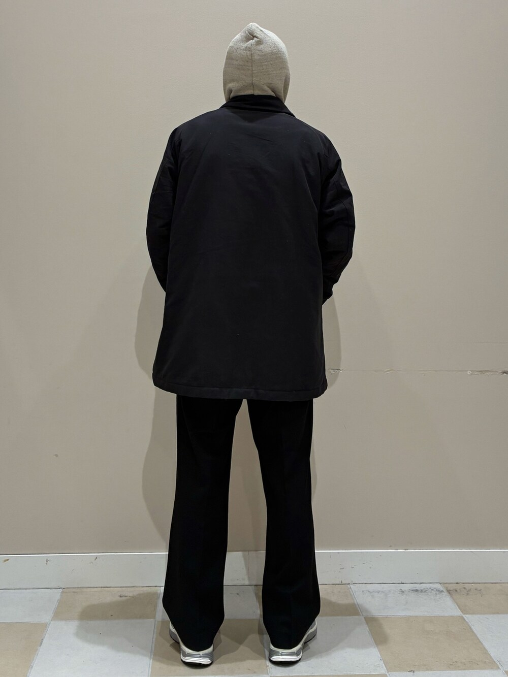 ブラック系のその他パンツ、ブラック系のステンカラーコート、グレー系のパーカーを着用したメンズの冬コーディネートの3枚目の写真