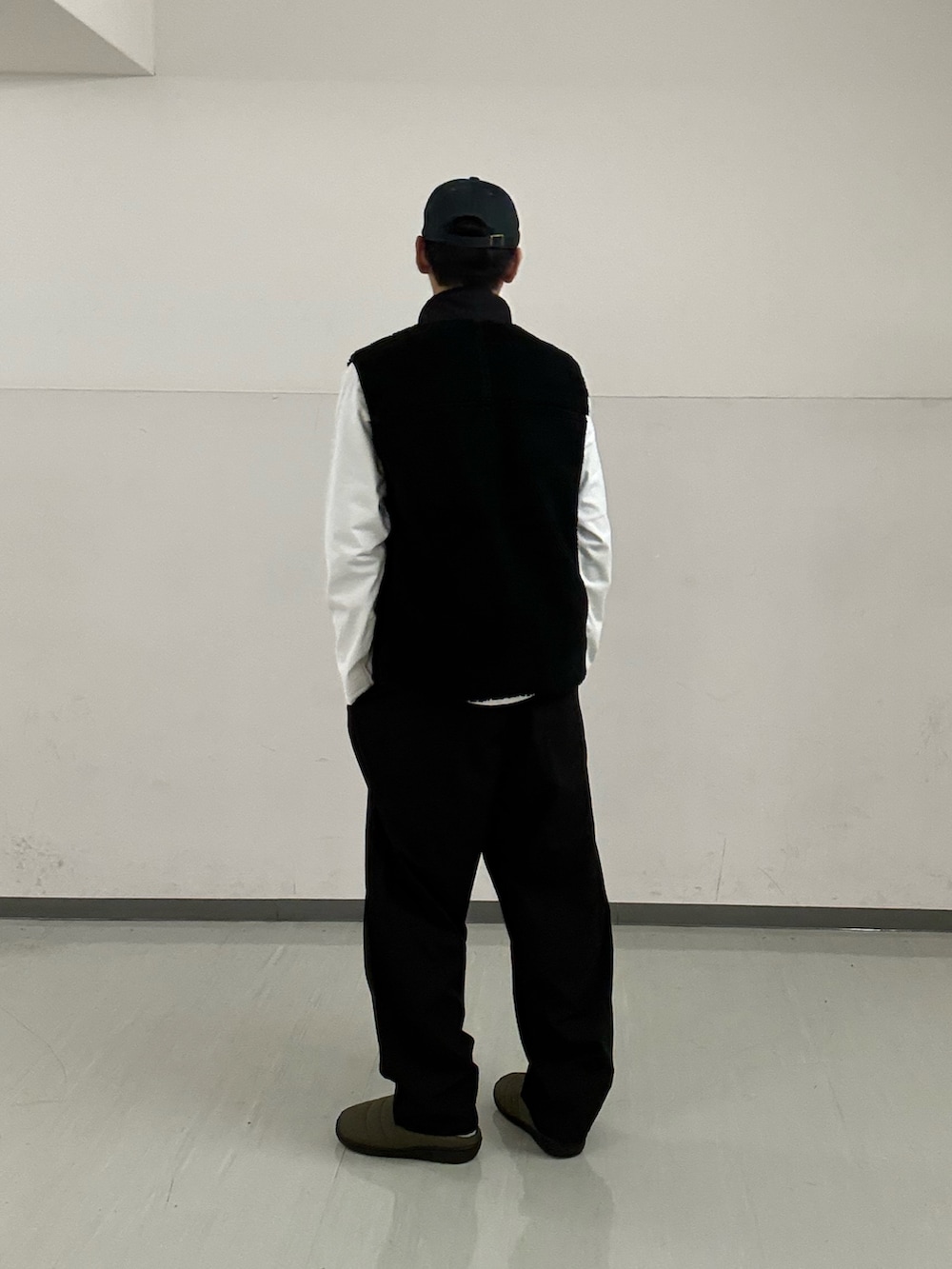 ブラック系のその他パンツ、ホワイト系のTシャツ/カットソー、ブラック系のベストを着用したメンズの秋コーディネートの3枚目の写真
