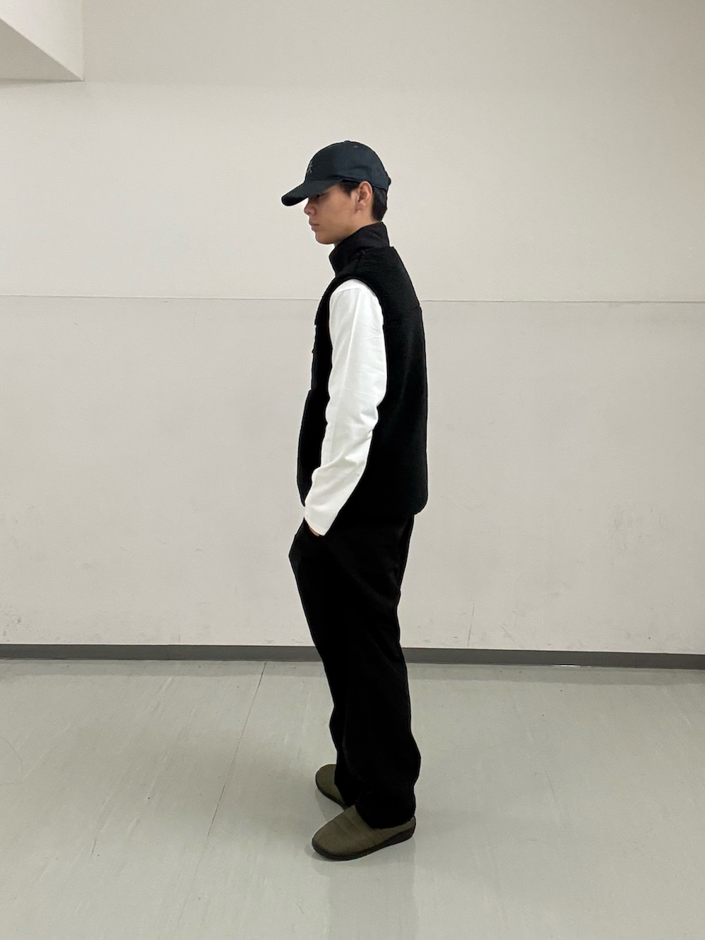 ブラック系のその他パンツ、ホワイト系のTシャツ/カットソー、ブラック系のベストを着用したメンズの秋コーディネートの2枚目の写真