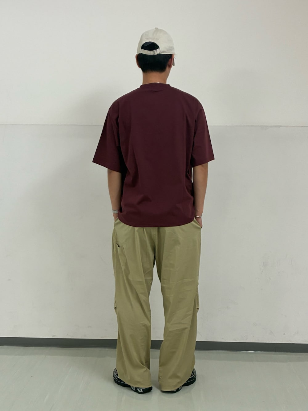 レッド系のTシャツ/カットソー、ベージュ系のその他パンツ、ホワイト系のキャップを着用したメンズの夏コーディネートの3枚目の写真