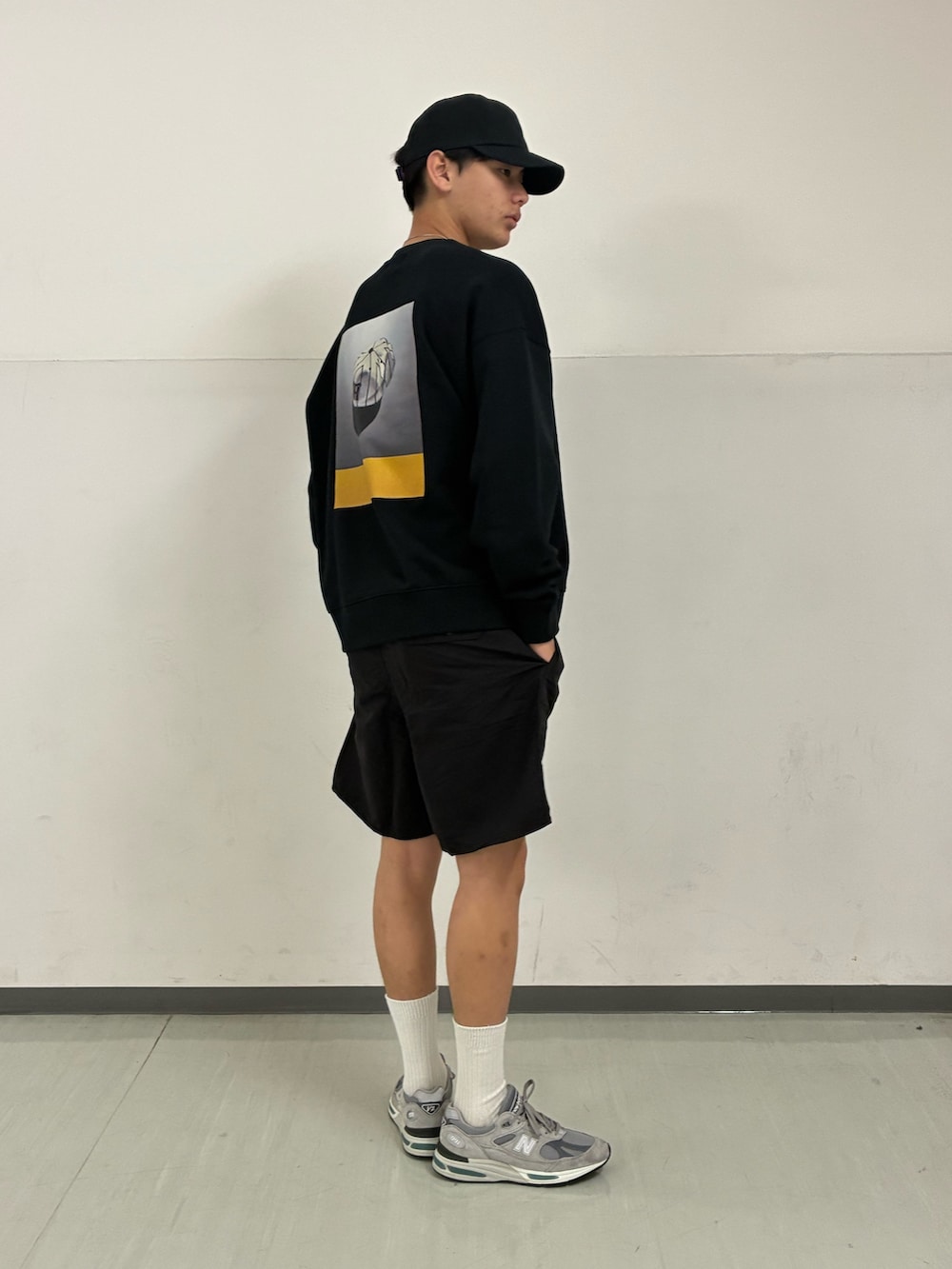 ブラック系のその他パンツ、ブラック系のキャップを着用したメンズの春コーディネートの2枚目の写真