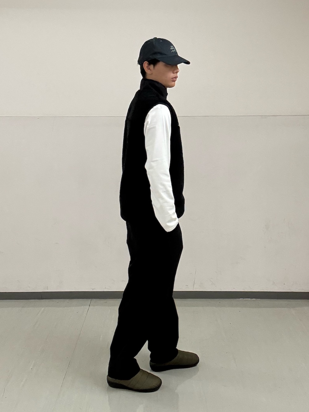 ブラック系のその他パンツ、ホワイト系のTシャツ/カットソー、ブラック系のベストを着用したメンズの秋コーディネートの4枚目の写真