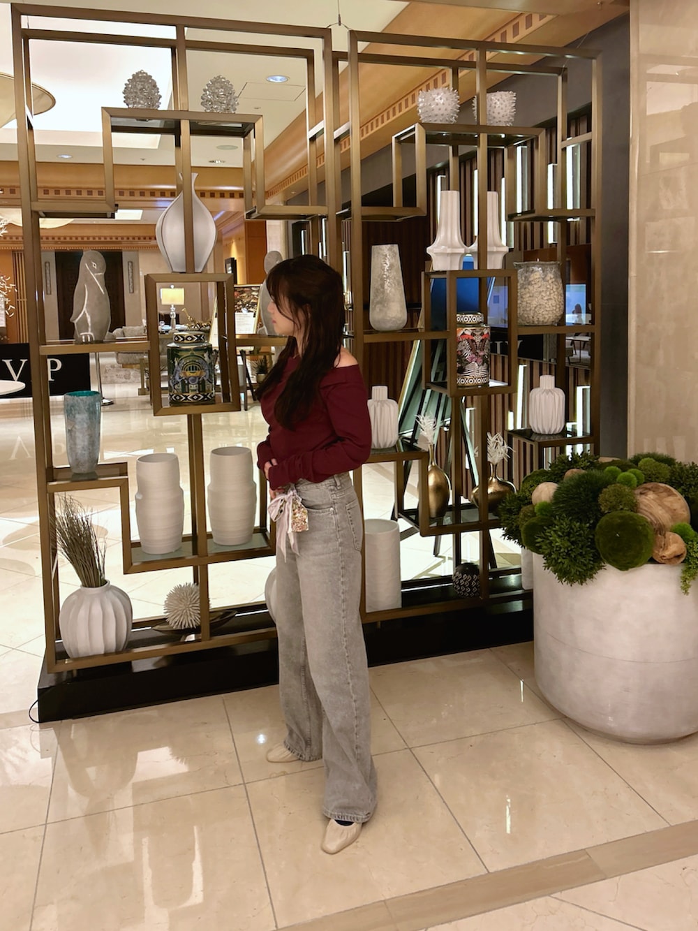 レッド系のトップス、グレー系のデニムパンツ、ピンク系のバンダナ/スカーフを着用したレディースの秋コーディネートの2枚目の写真