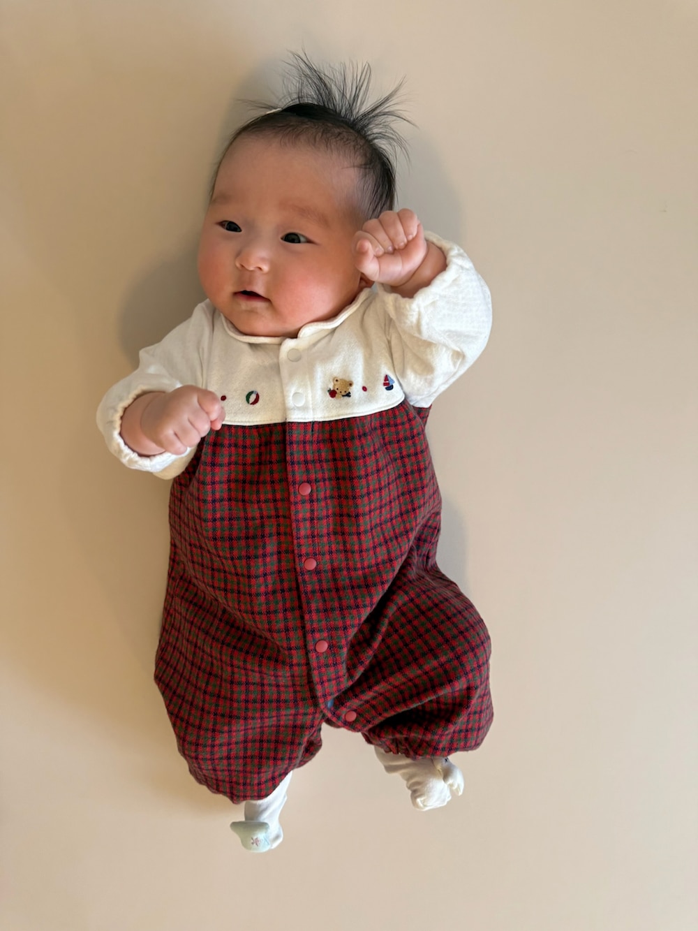 レッド系のロンパース、ホワイト系のヘアピン、ホワイト系のソックス/靴下を着用したキッズの春コーディネートの2枚目の写真