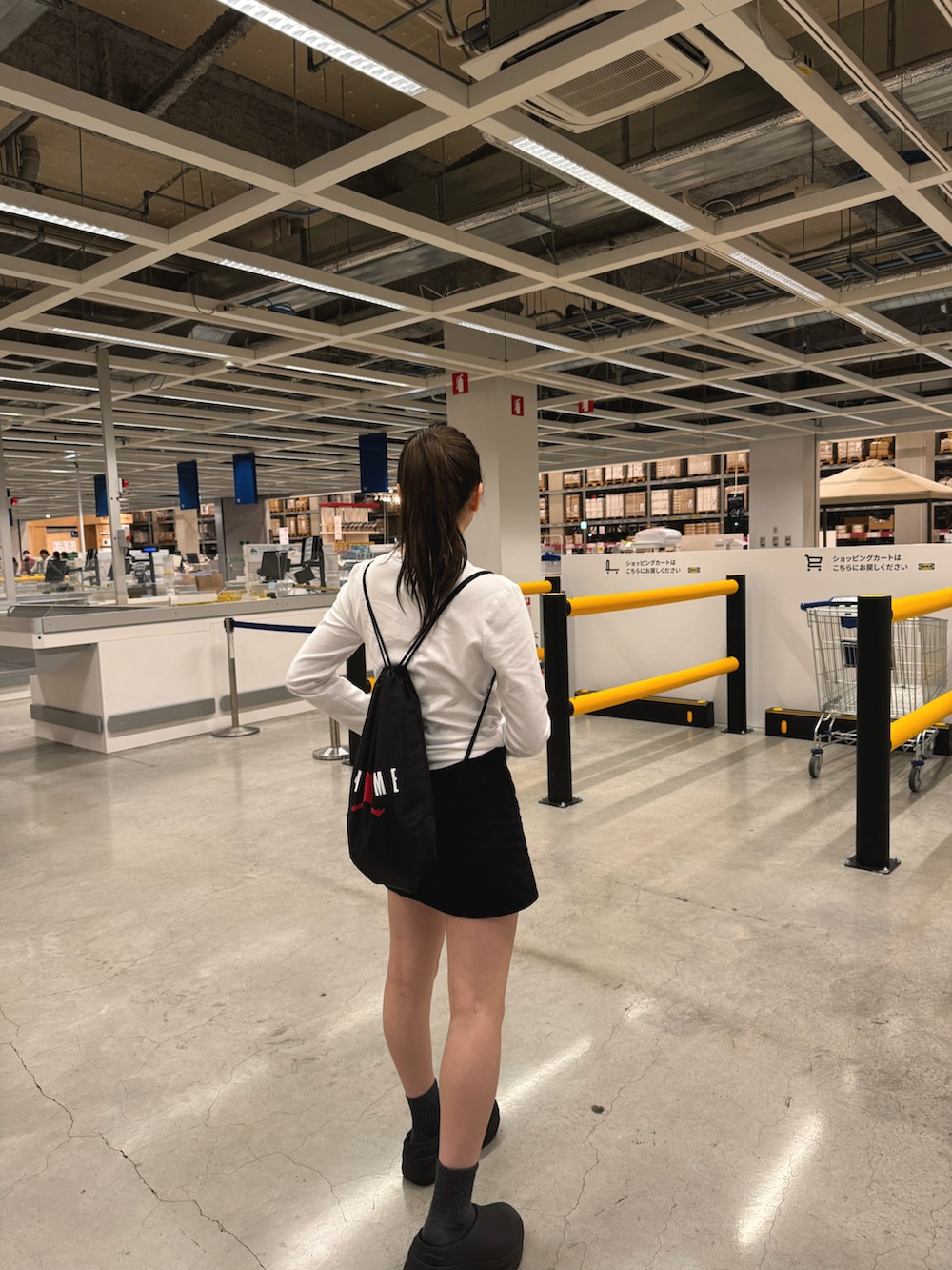 ブラック系のサンダル、ブラック系のバッグ、ホワイト系のTシャツ/カットソーを着用したレディースの秋コーディネートの2枚目の写真