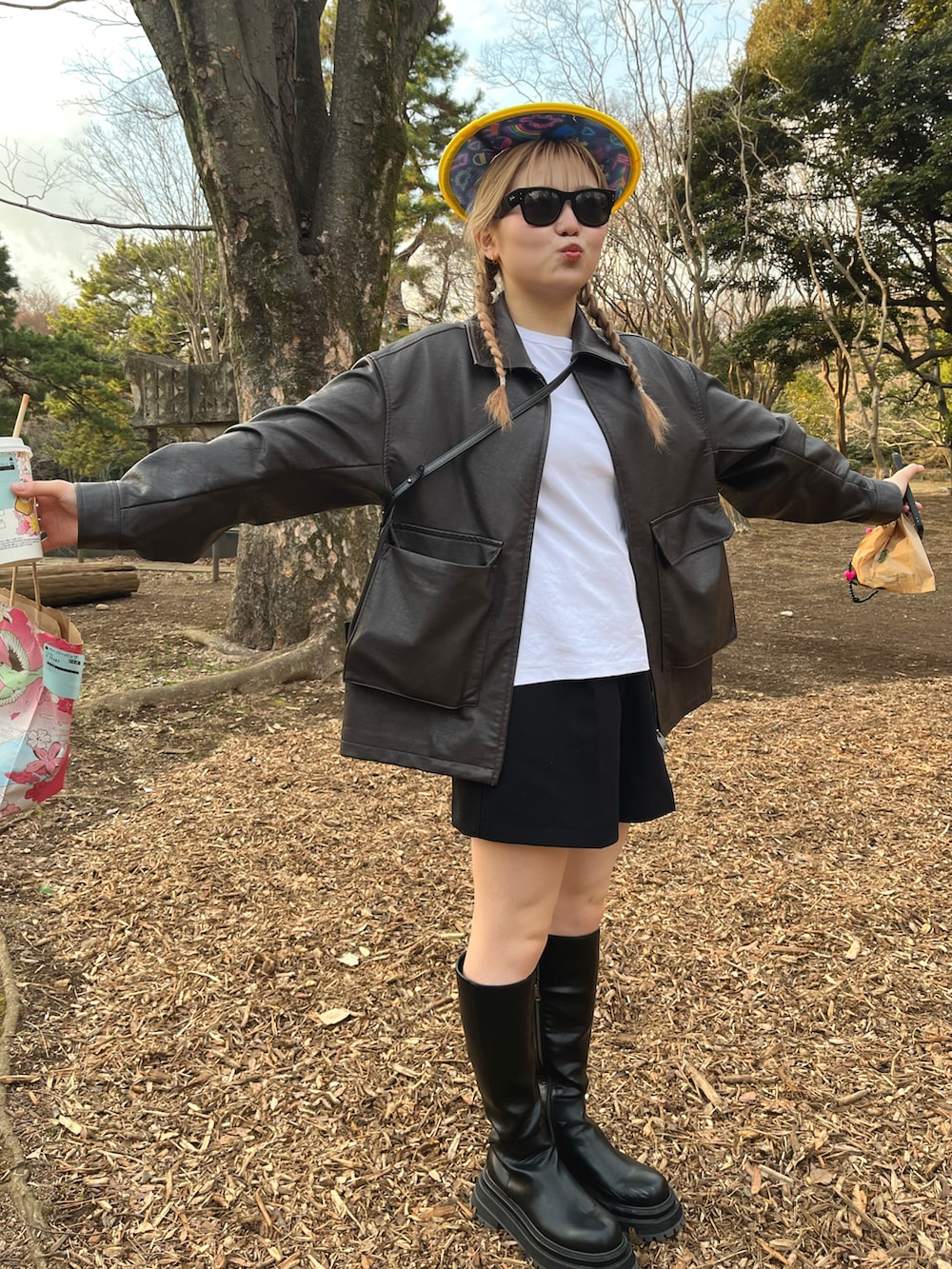 ブラウン系のライダースジャケット、ブラック系のパンツ、ブラック系のサングラスを着用したレディースの春コーディネートの4枚目の写真