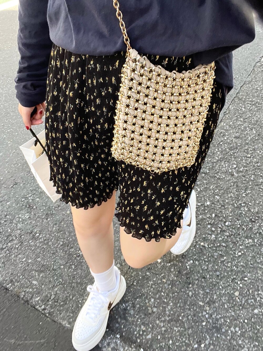 ブラック系のスカート、ゴールド系のショルダーバッグ、ブルー系のTシャツ/カットソーを着用したレディースの秋コーディネートの2枚目の写真