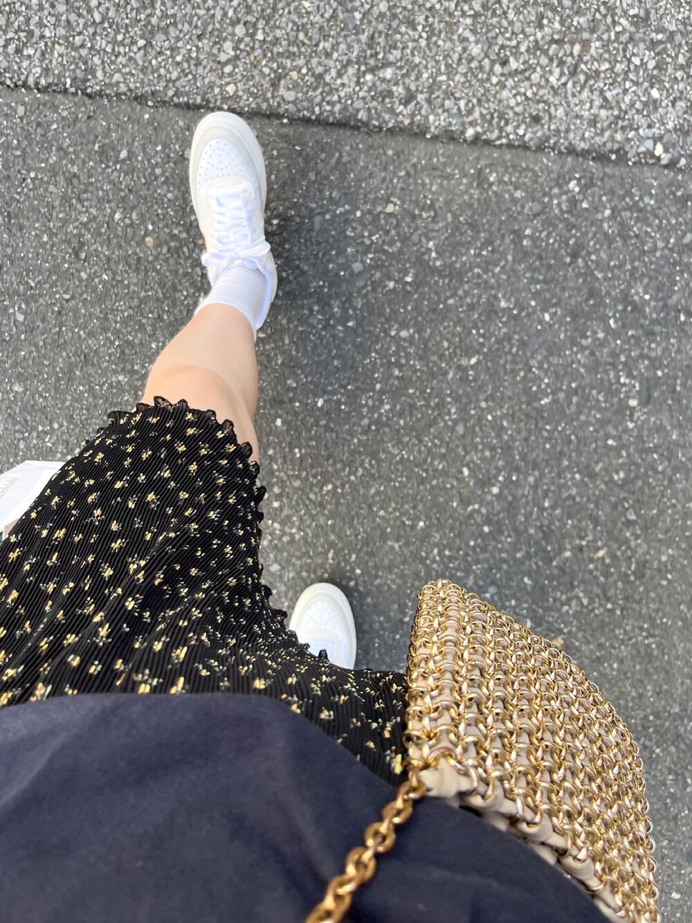 ブラック系のスカート、ゴールド系のショルダーバッグ、ブルー系のTシャツ/カットソーを着用したレディースの秋コーディネートの3枚目の写真