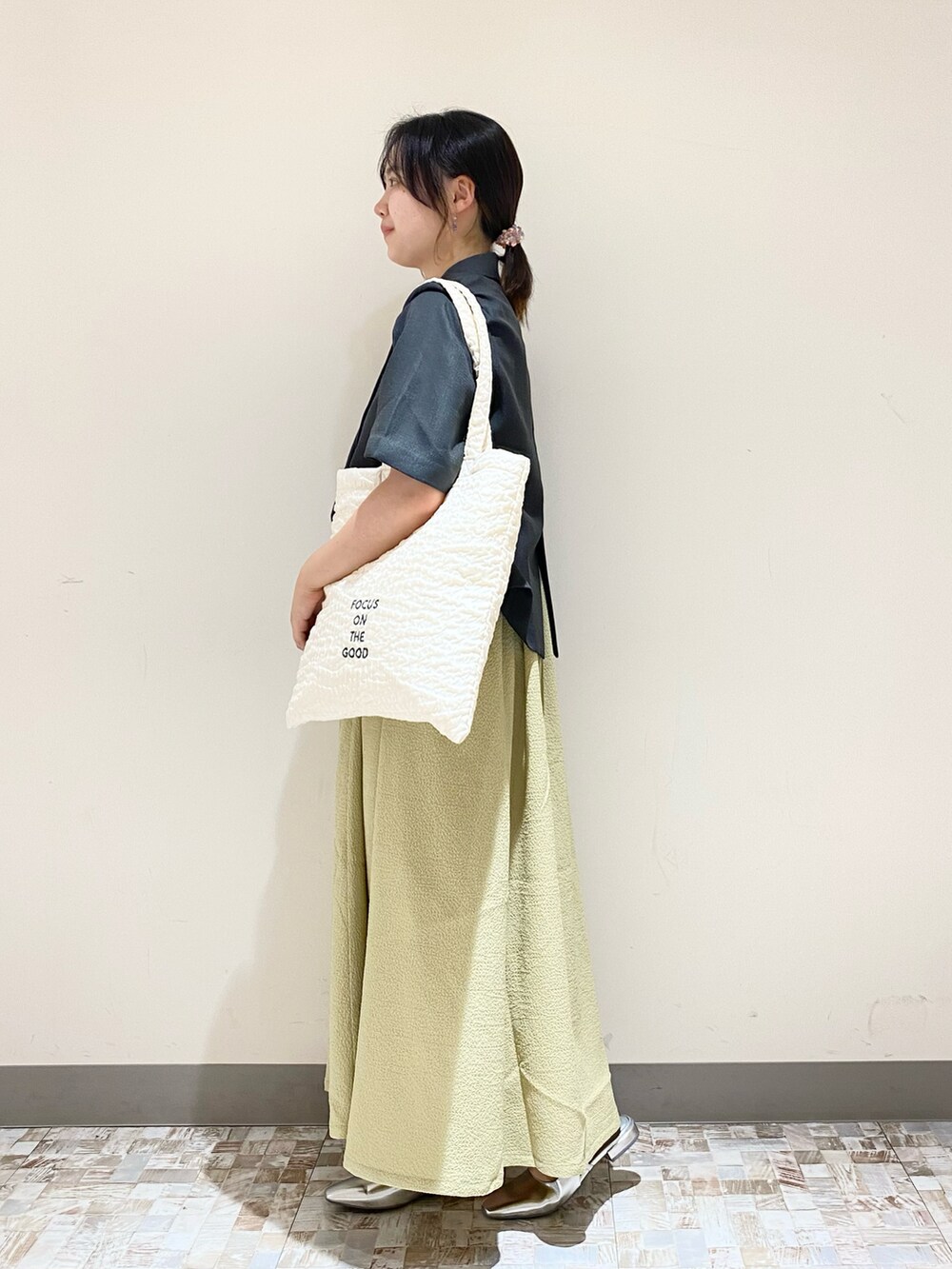 ブラック系のジャケット/アウター、グリーン系のワンピース、シルバー系のサンダルを着用したレディースの夏コーディネートの2枚目の写真