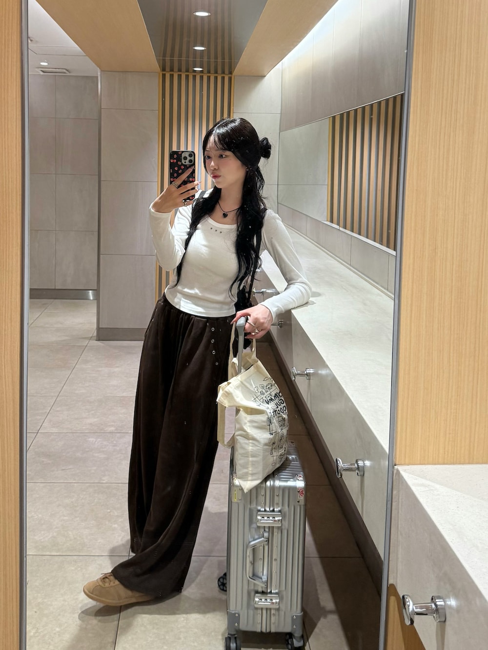 ホワイト系のTシャツ/カットソー、ブラウン系のスウェットパンツ、ブラウン系のスニーカーを着用したレディースの秋コーディネートの4枚目の写真