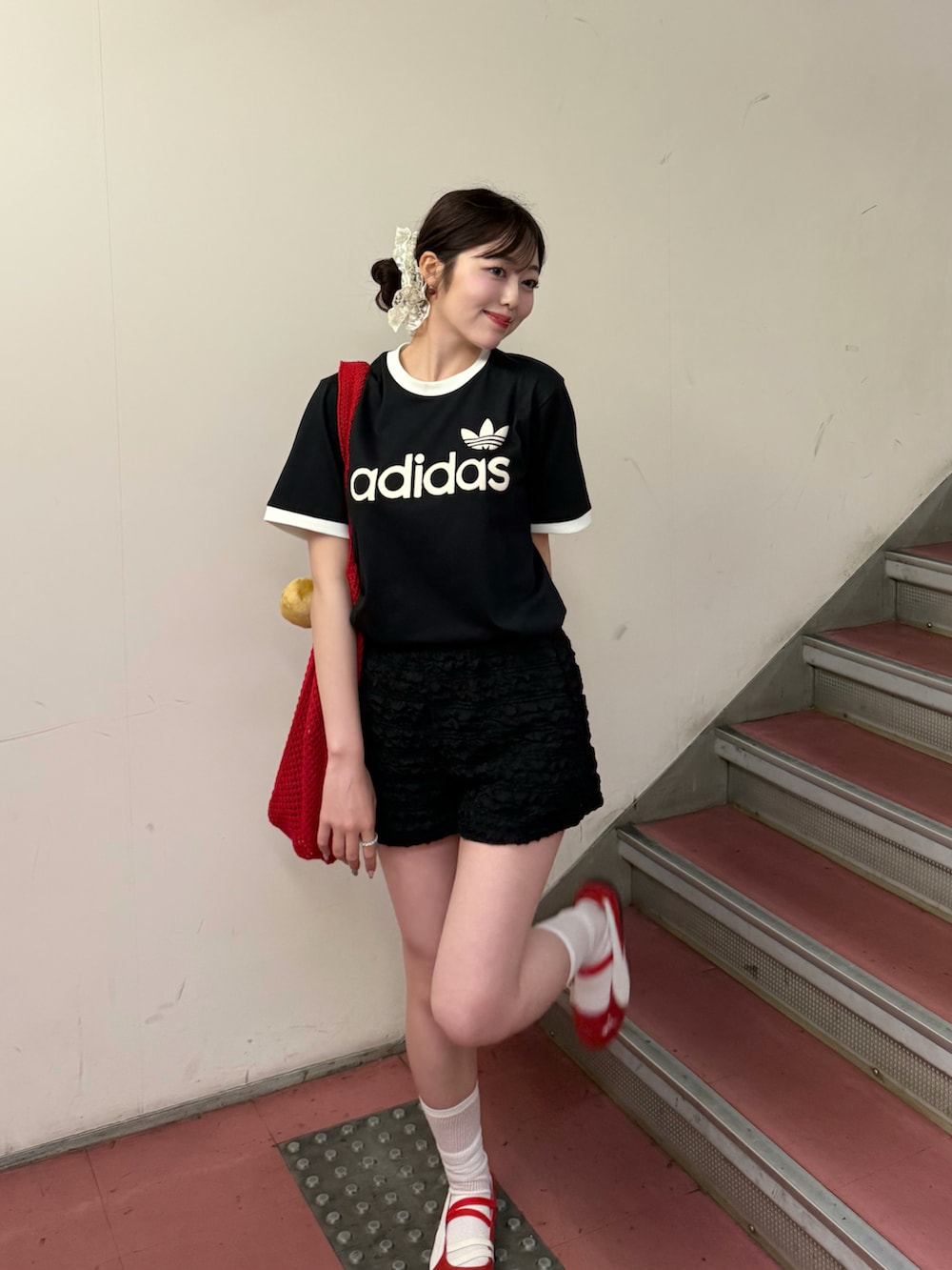 ブラック系のTシャツ/カットソー、ブラック系のスウェットパンツ、レッド系のトートバッグを着用したレディースの夏コーディネートの3枚目の写真