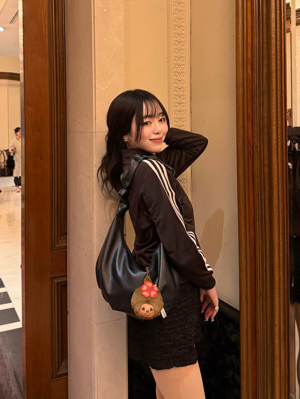 ブラウン系のジャージ、ブラック系のパンツ、ブラック系のサンダルを着用したレディースの春コーディネートの3枚目の写真