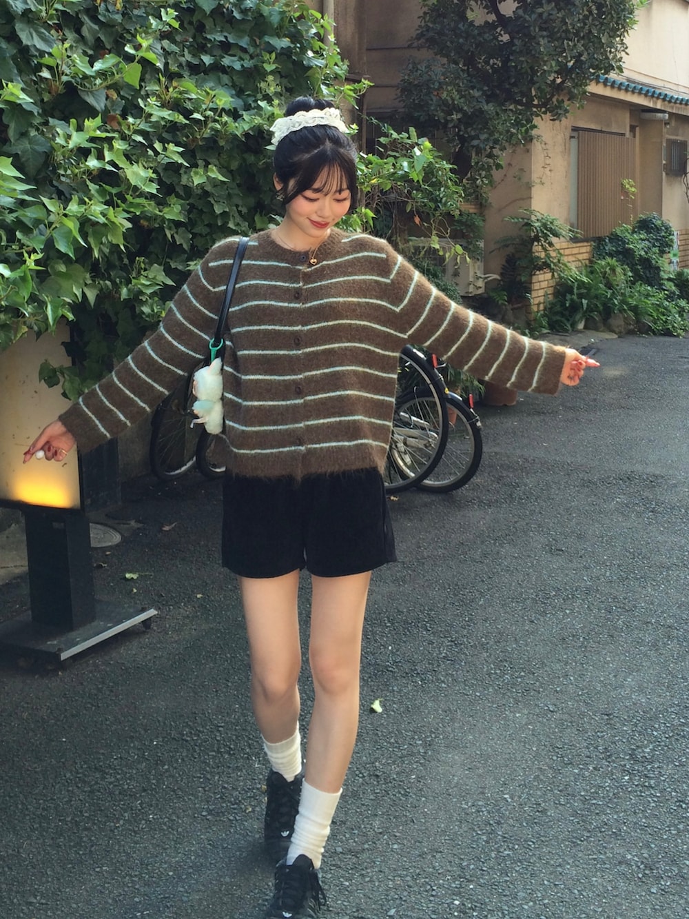 ブラウン系のカーディガン/ボレロ、ブラック系のその他パンツ、ブラック系のスニーカーを着用したレディースの秋コーディネートの3枚目の写真