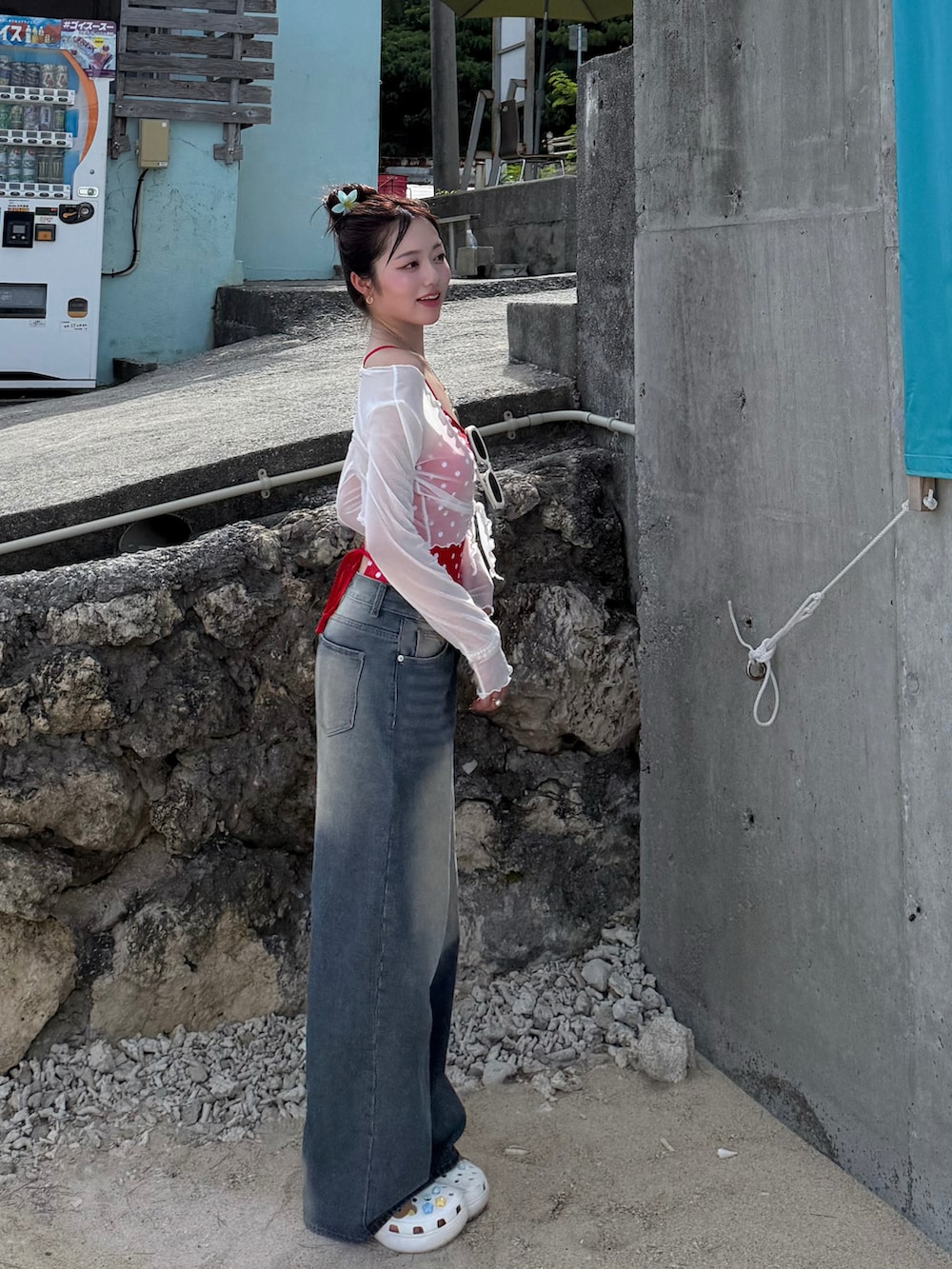 ブルー系のデニムパンツ、ホワイト系のサンダル、レッド系の水着を着用したレディースの夏コーディネートの2枚目の写真