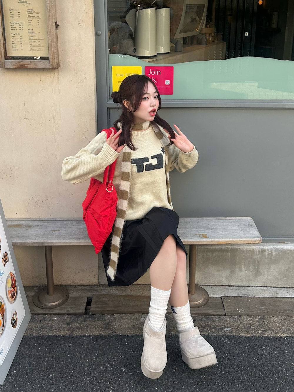 ベージュ系のニット/セーター、ブラック系のスカート、レッド系のショルダーバッグを着用したレディースの冬コーディネートの3枚目の写真