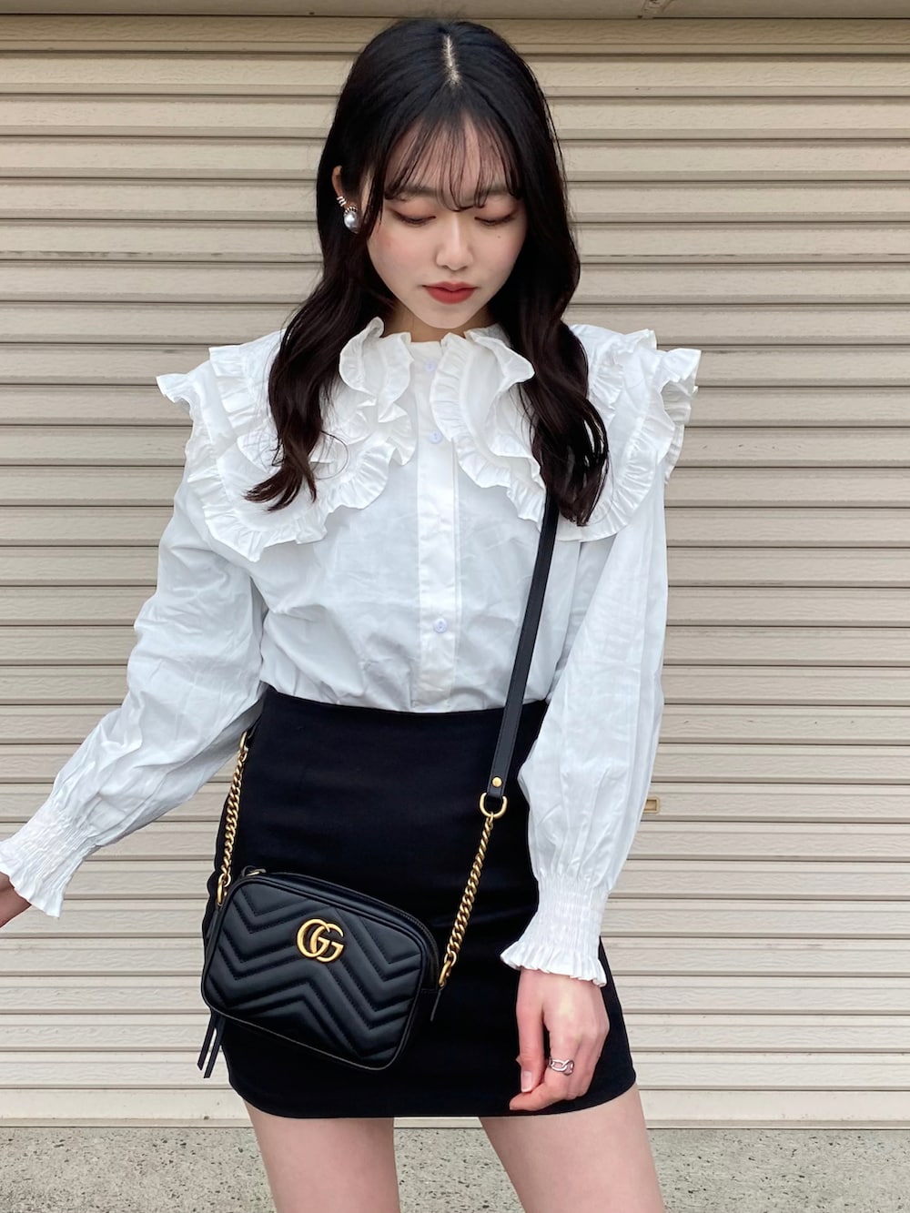 ホワイト系のTシャツ/カットソー、ブラック系のスカート、ブラック系のローファーを着用したレディースの冬コーディネートの2枚目の写真