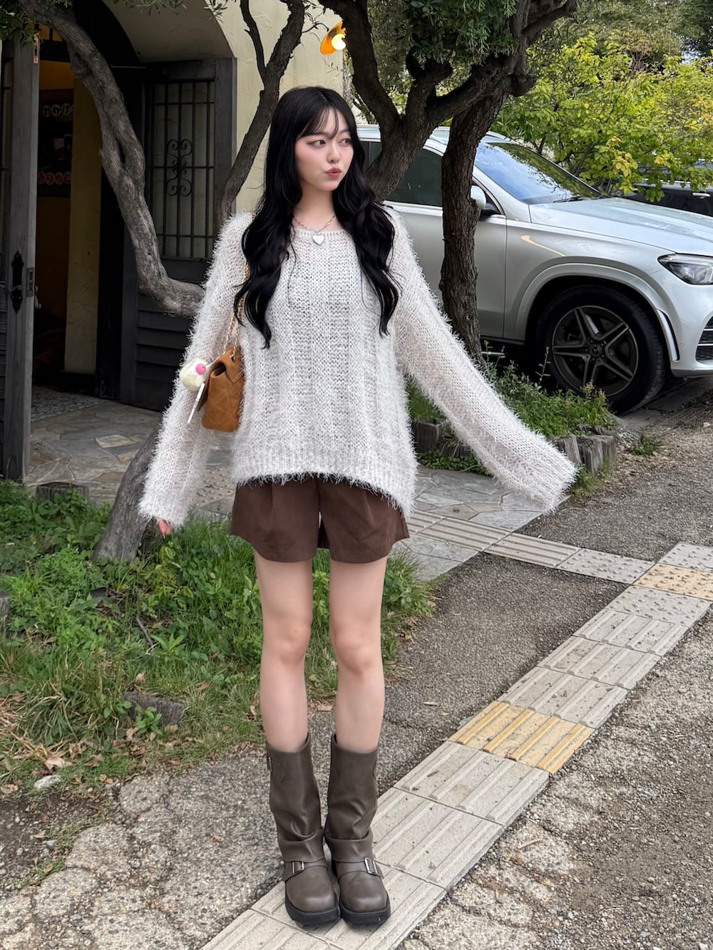 ベージュ系のニット/セーター、ブラウン系のその他パンツ、ブラウン系のブーツを着用したレディースの秋コーディネートの2枚目の写真