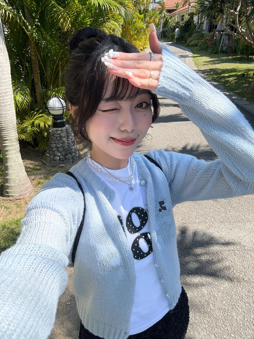 ホワイト系のTシャツ/カットソー、ブラック系のパンツ、ホワイト系のスニーカーを着用したレディースの春コーディネートの3枚目の写真