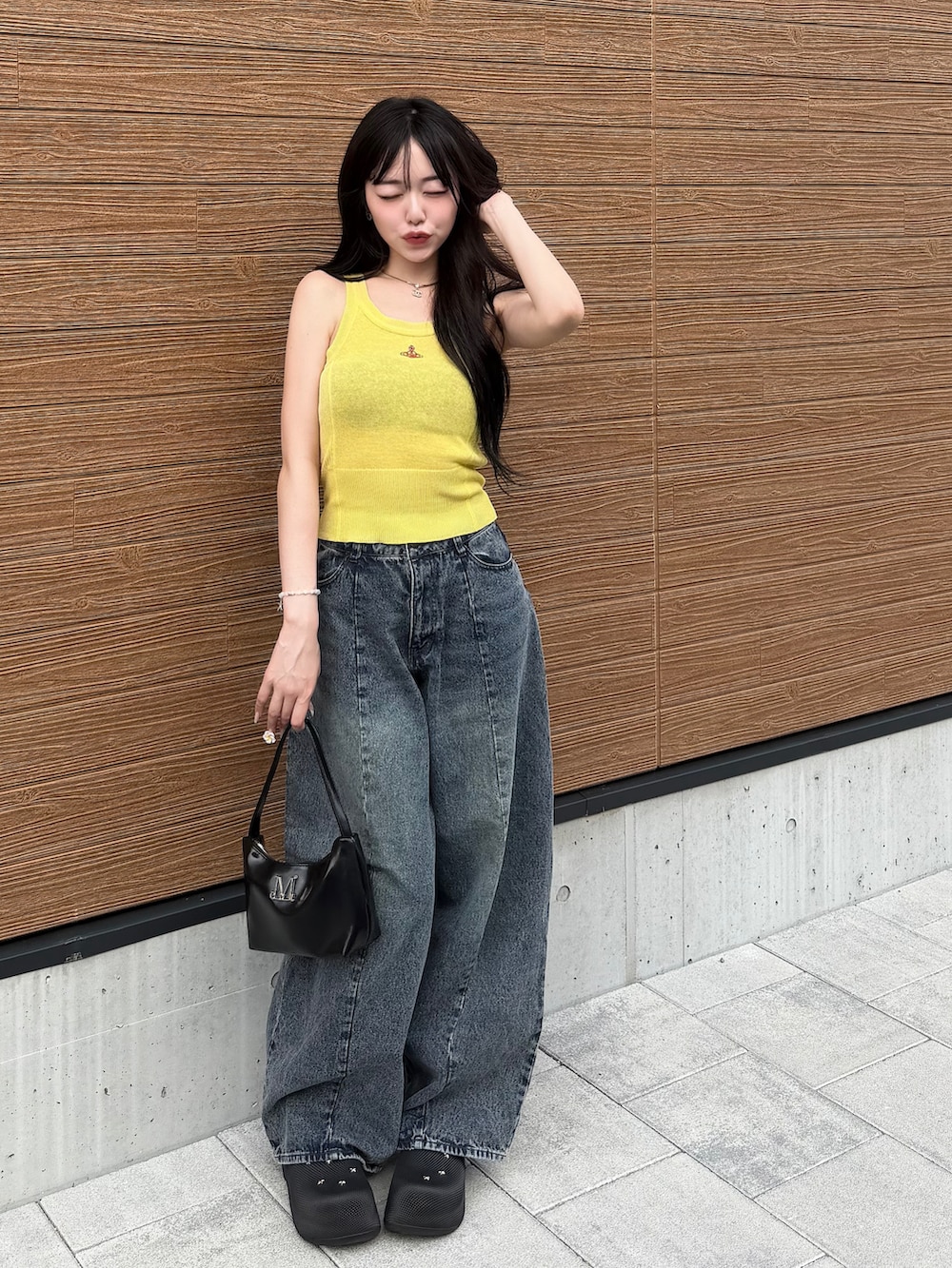 イエロー系のカーディガン/ボレロ、ブラック系のデニムパンツ、ブラック系のサンダルを着用したレディースの夏コーディネートの2枚目の写真
