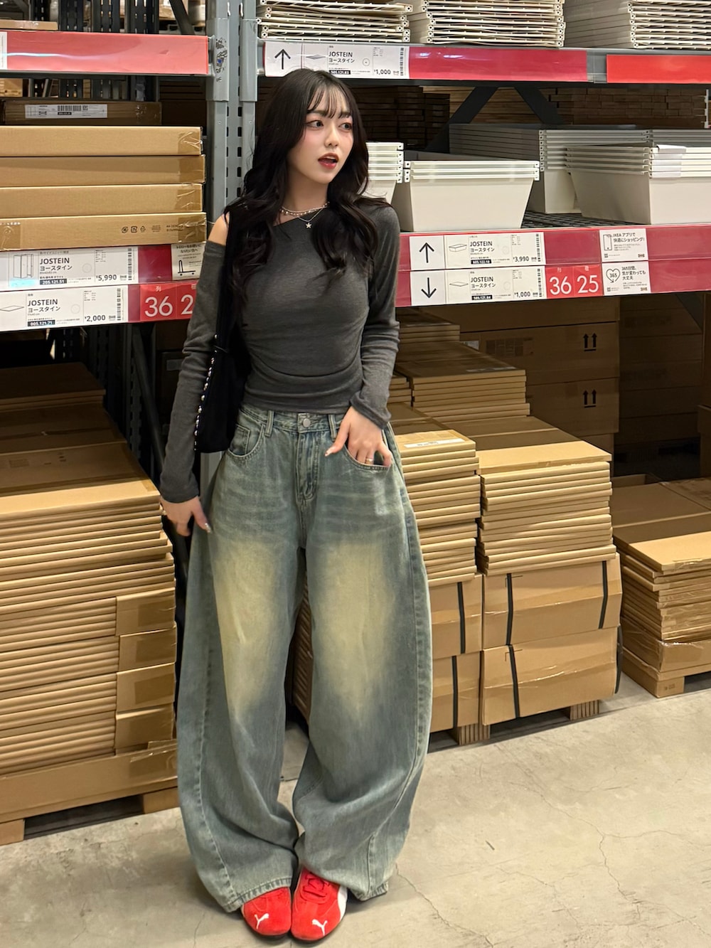 ブルー系のデニムパンツ、レッド系のスニーカー、グレー系のTシャツ/カットソーを着用したレディースの春コーディネートの2枚目の写真