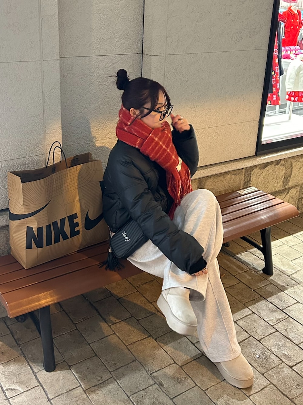 グレー系のスウェットパンツ、ブラック系のダウンジャケット/コート、ブラック系のショルダーバッグを着用したレディースの冬コーディネートの2枚目の写真