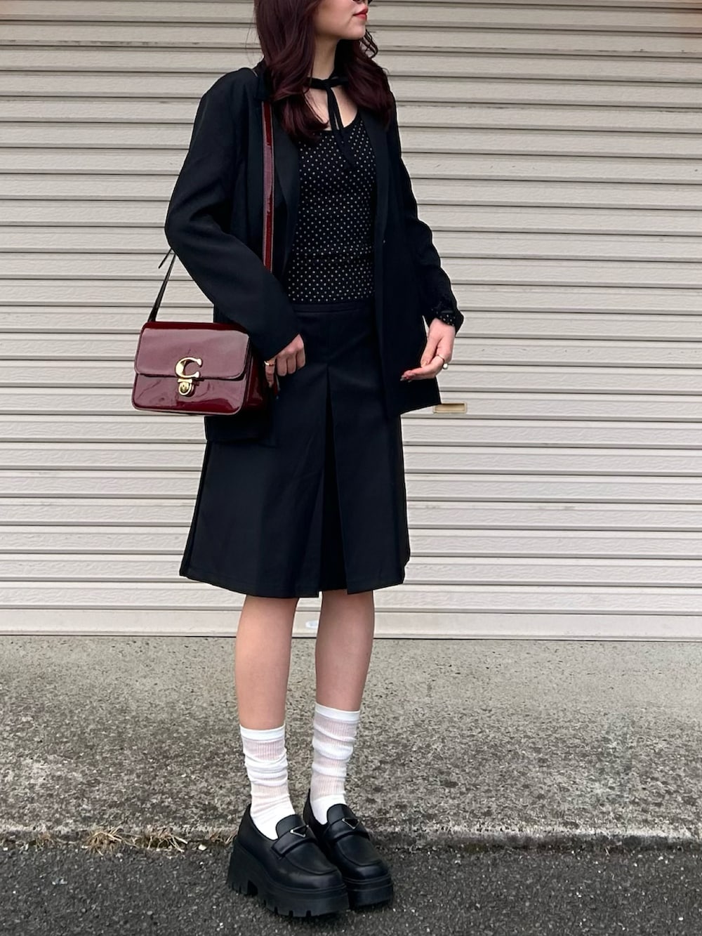 ブラック系のTシャツ/カットソー、ブラック系のテーラードジャケット、ブラック系のスカートを着用したレディースの冬コーディネートの2枚目の写真