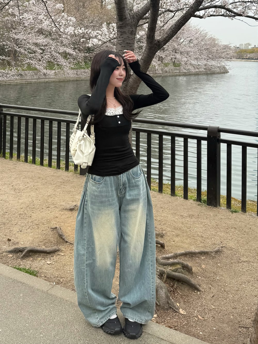 ブラック系のTシャツ/カットソー、ブルー系のデニムパンツ、ブラック系のサンダルを着用したレディースの春コーディネートの2枚目の写真