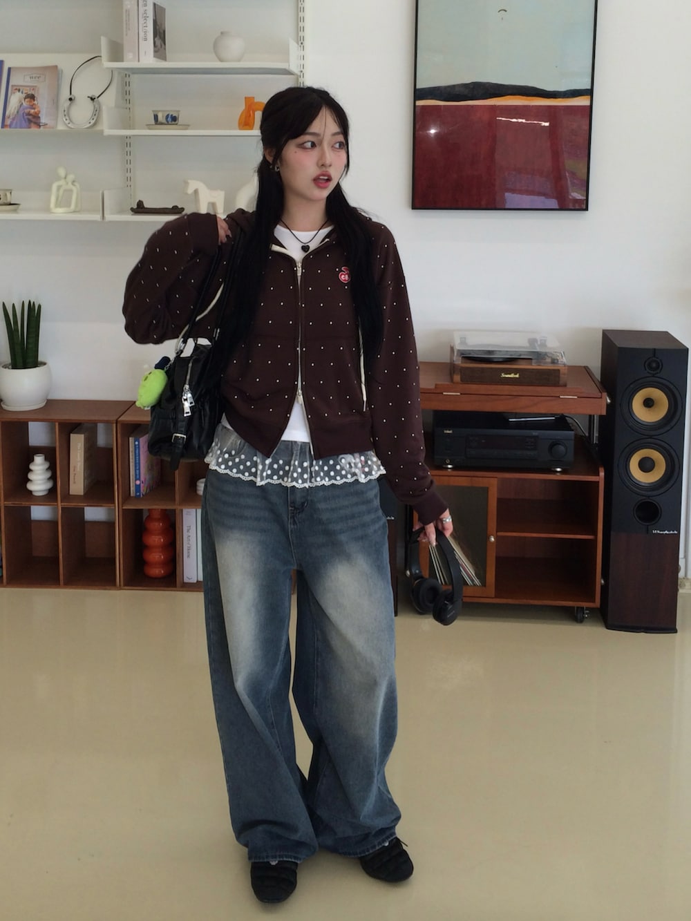 ブルー系のデニムパンツ、ブラウン系のパーカー、ブラック系のスニーカーを着用したレディースの秋コーディネートの2枚目の写真