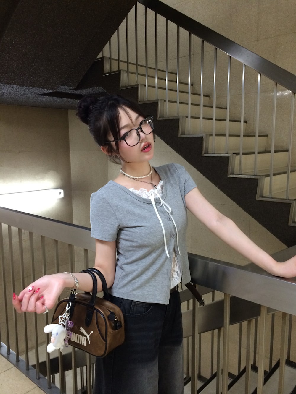 グレー系のTシャツ/カットソー、ブラック系のデニムパンツ、ブラウン系のスニーカーを着用したレディースの夏コーディネートの3枚目の写真