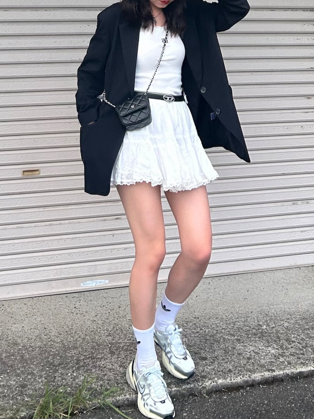 ホワイト系のスニーカー、ブラック系のキャップ、ブラック系のベルトを着用したレディースの冬コーディネートの2枚目の写真