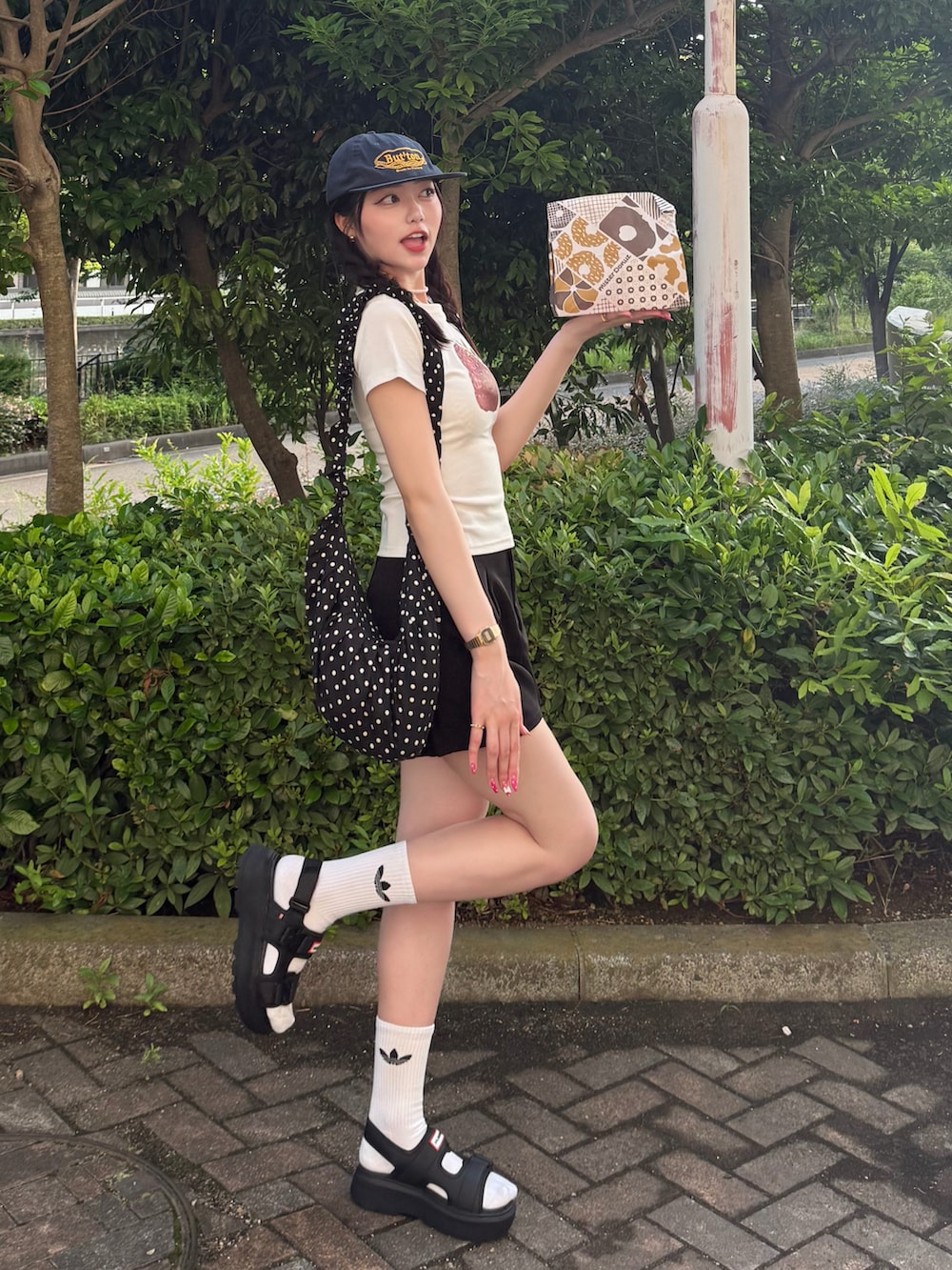 ホワイト系のTシャツ/カットソー、ブラック系のパンツ、ブラック系のショルダーバッグを着用したレディースの夏コーディネートの2枚目の写真