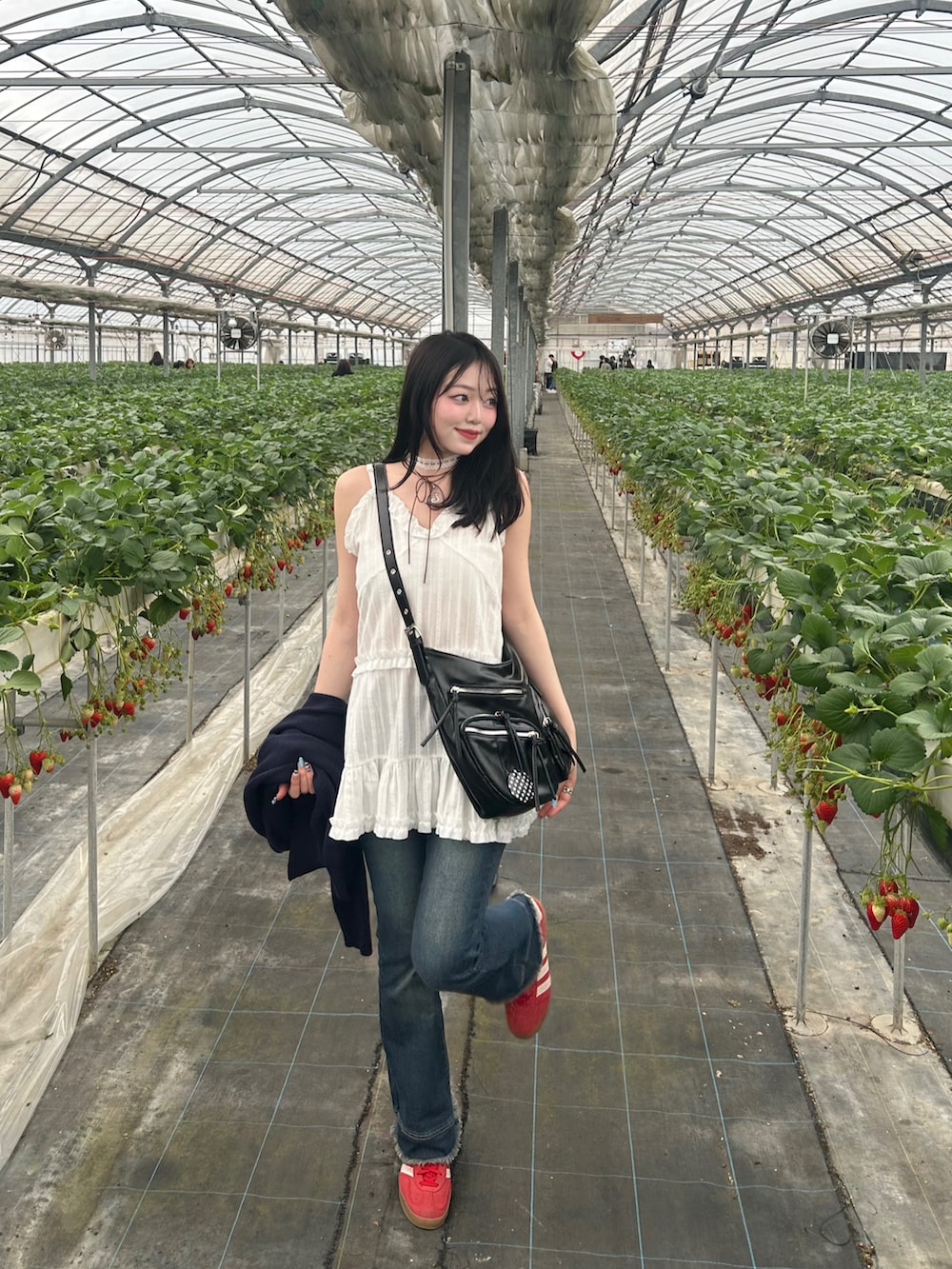 ホワイト系のキャミソール、ブルー系のカーディガン/ボレロ、ブルー系のデニムパンツを着用したレディースの春コーディネートの3枚目の写真