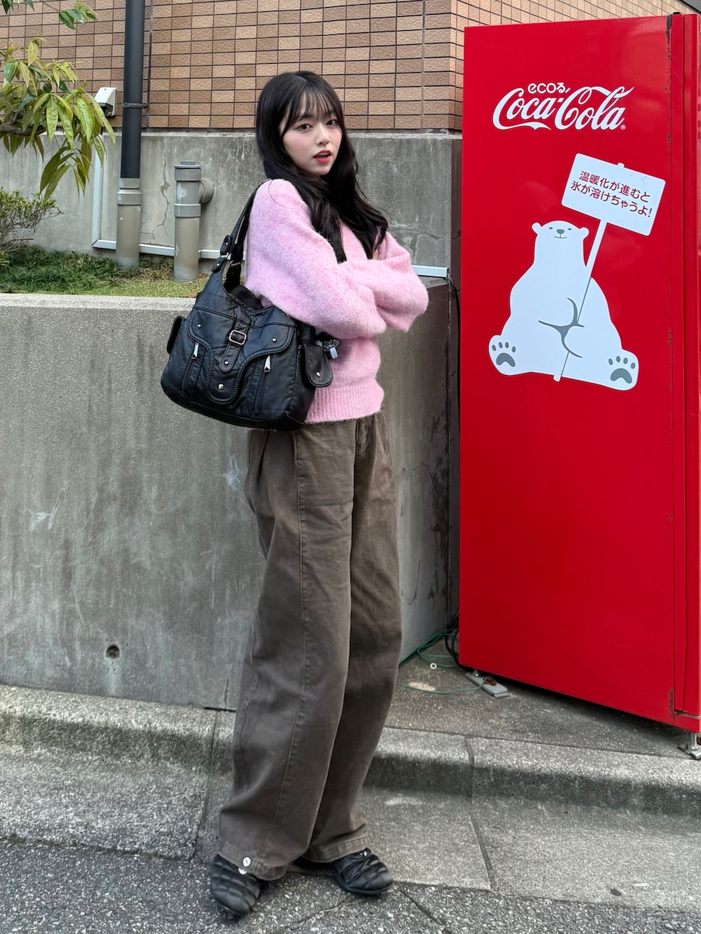 ピンク系のニット/セーター、ブラウン系のデニムパンツ、ブラック系のスニーカーを着用したレディースの秋コーディネートの3枚目の写真