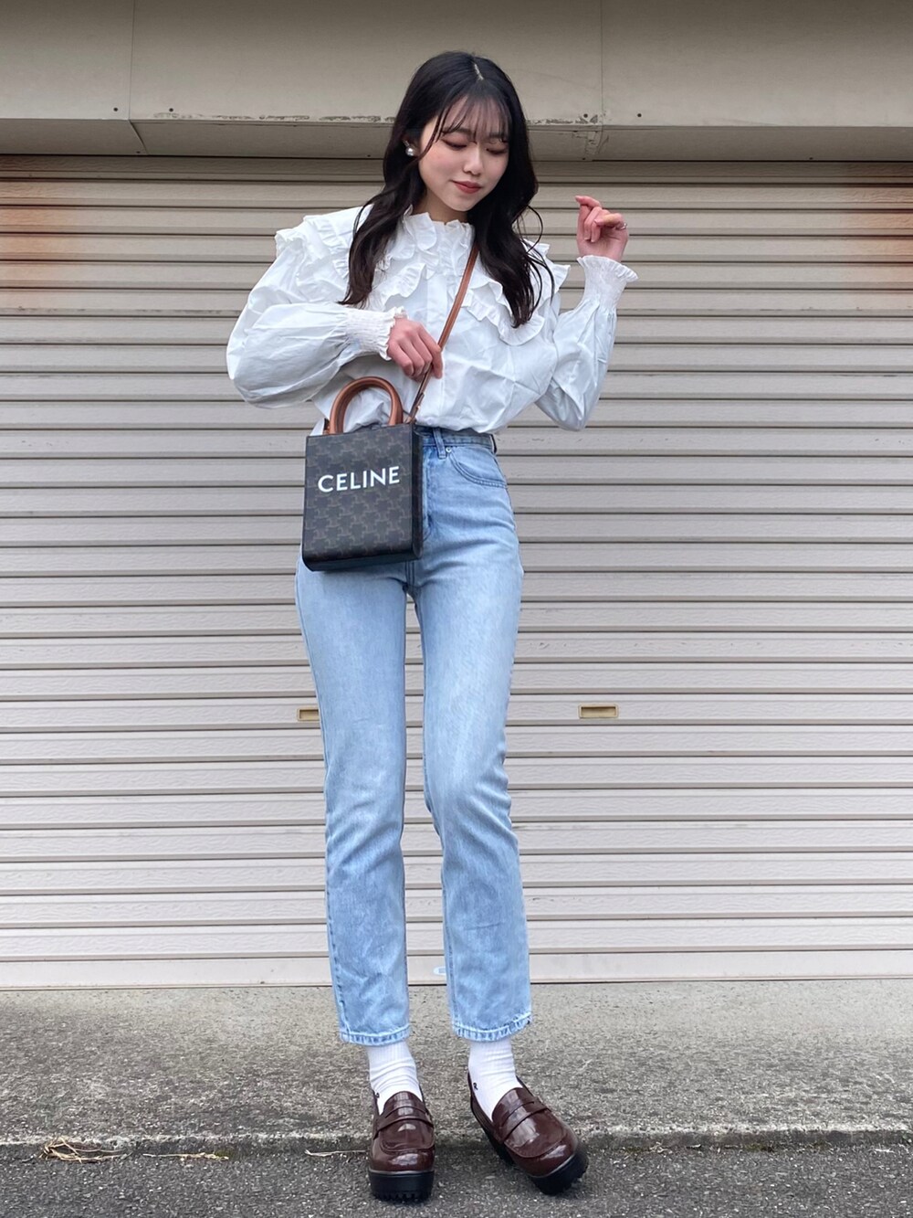 ホワイト系のTシャツ/カットソー、ブルー系のデニムパンツ、ブラック系のローファーを着用したレディースの冬コーディネートの3枚目の写真