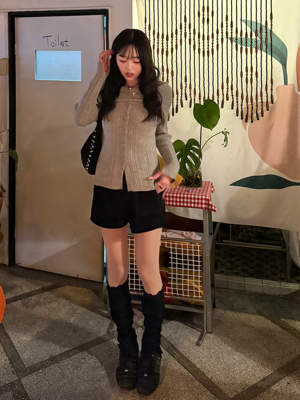 ベージュ系のニット/セーター、ブラック系のその他パンツ、ブラック系のハンドバッグを着用したレディースの冬コーディネートの2枚目の写真