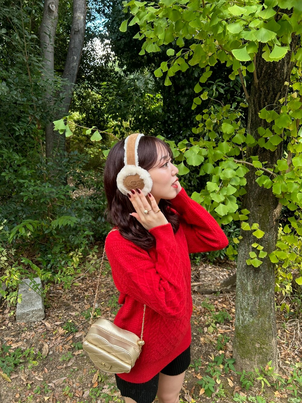 レッド系のニット/セーター、ゴールド系のショルダーバッグ、ブラック系のブーツを着用したレディースの冬コーディネートの3枚目の写真